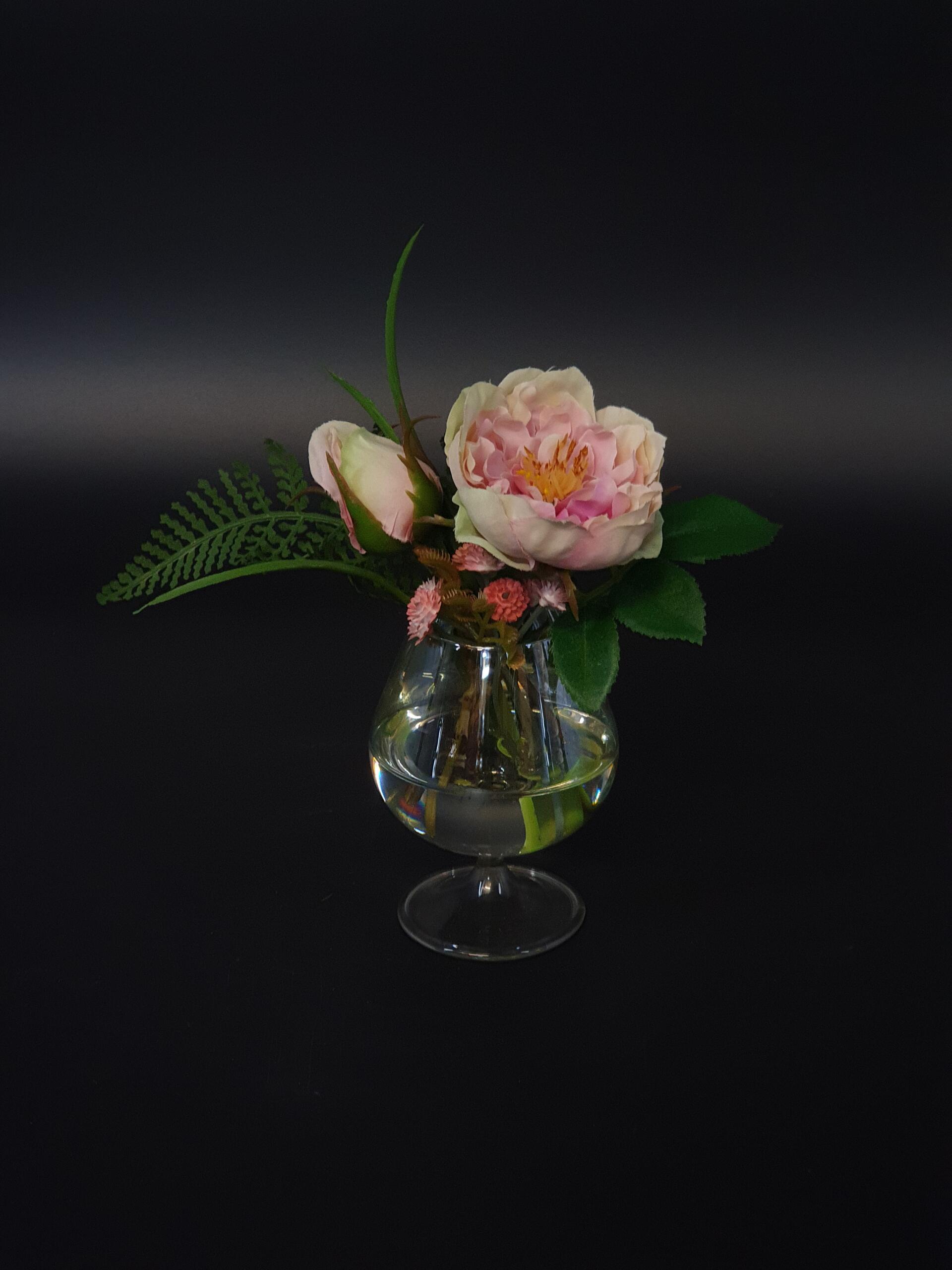 Fliederfarbene Rose mit Knospe im künstlichen Wasser.