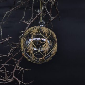 Edle Christbaumkugel aus Glas mit goldenem Ornamentdekor.